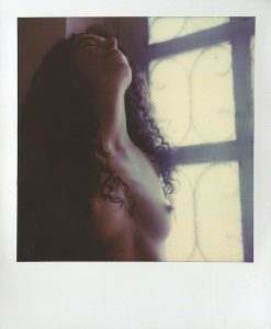 Polaroidfoto auf dem ein Frauenakt zu sehen ist
